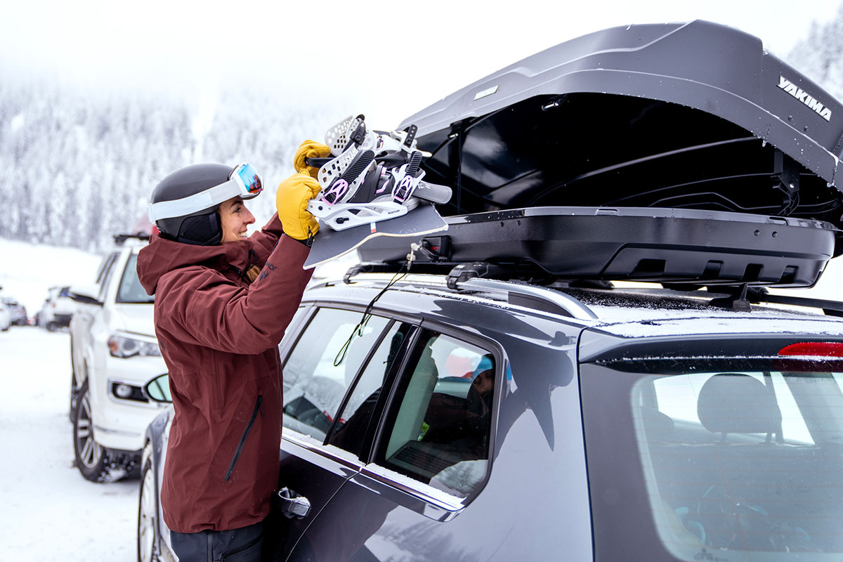 Yakima SkyBox NX 16 roof box (putting snowboard in box)